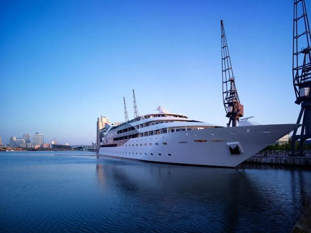 The Sunborn yacht moored in Royal Victoria Dock, with a dock crane beside it and Canary Wharf behind