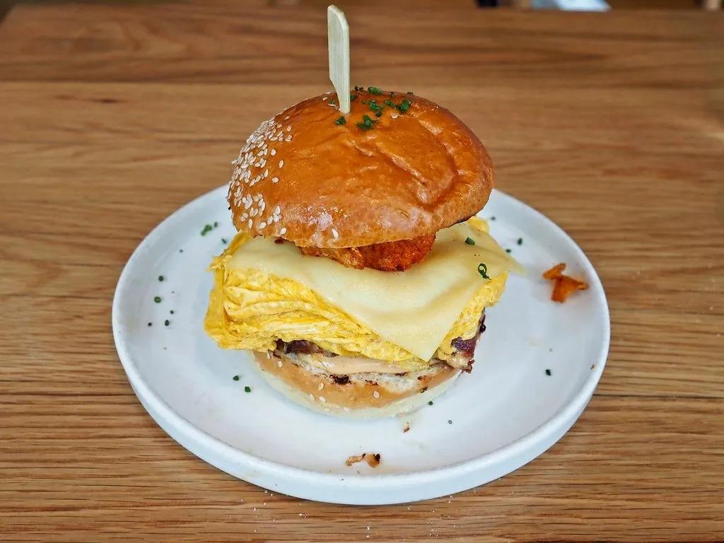 A breakfast sandwich with egg and cheese on a brioche bun