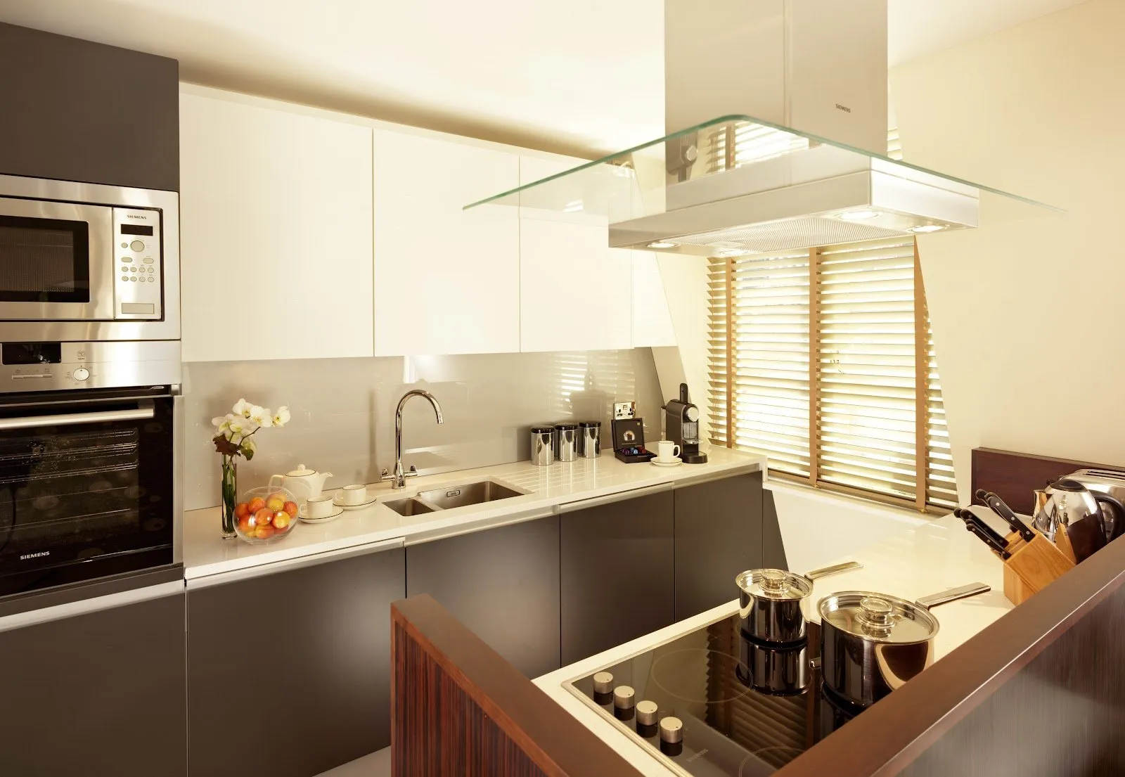 A modern kitchen in a suite at Taj 51 Buckingham Gate with induction hob, built-in microwave and fitted cabinetry