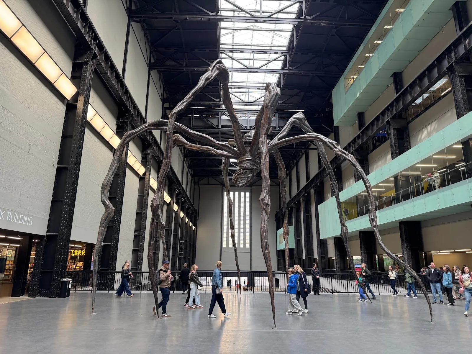 A giant spider sculpture standing in Tate Modern's cavernous Turbine Hall, dwarfing visitors below