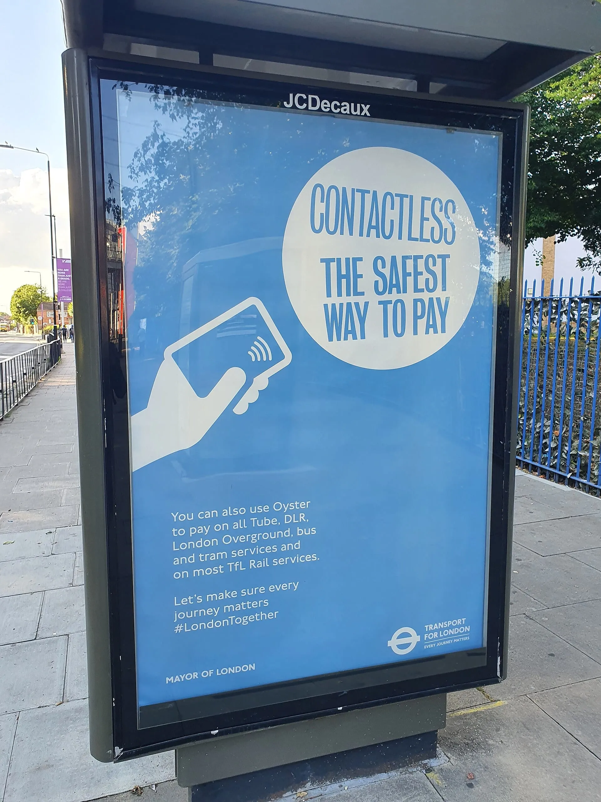 A Transport for London bus shelter poster advertising contactless payment as the safest way to pay