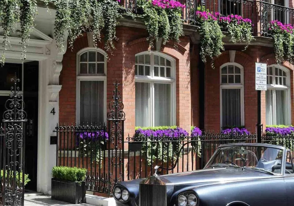 The Victorian red-brick facade of The Athenaeum Hotel & Residences on Piccadilly with wrought-iron balconies and window boxes