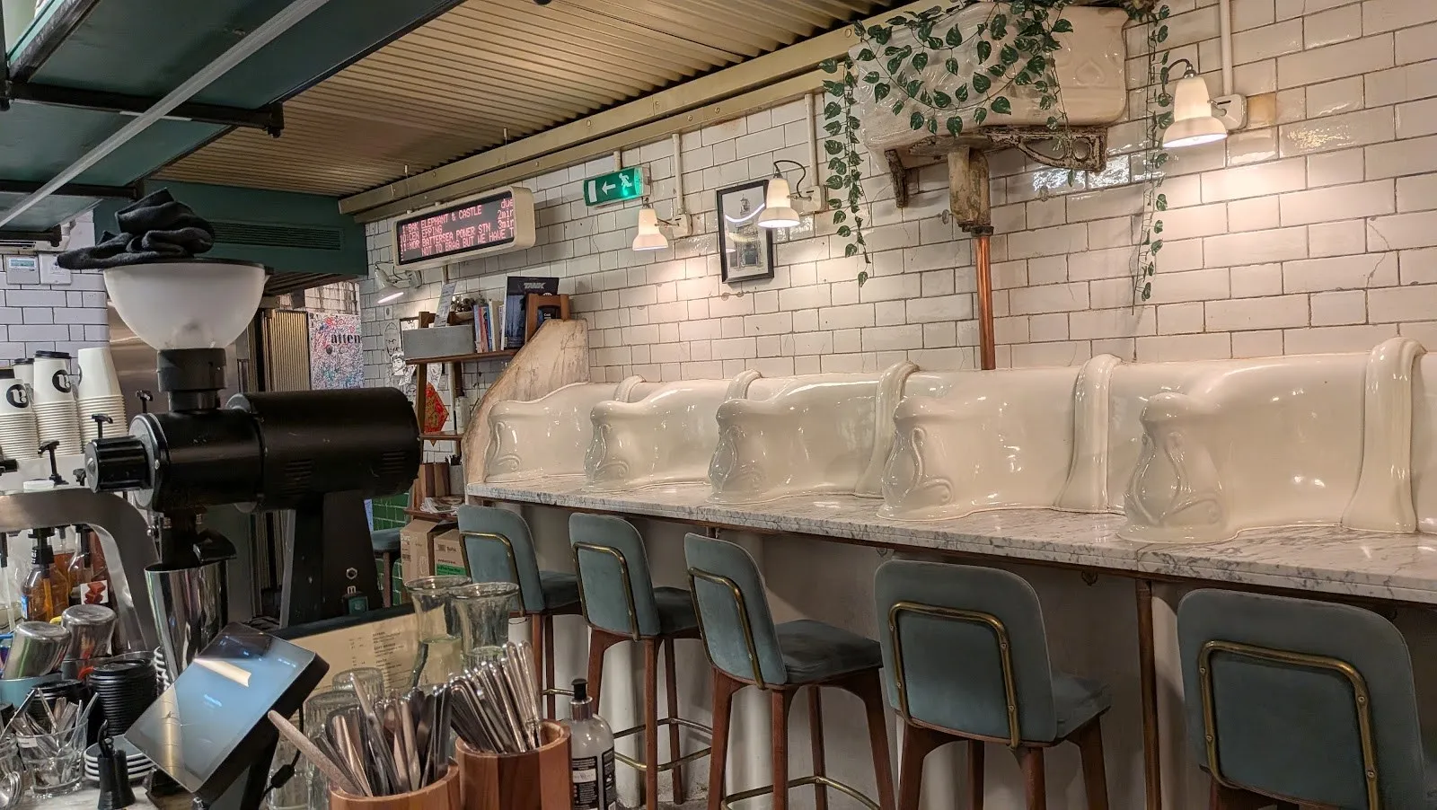A café counter built along a row of restored Victorian porcelain urinals