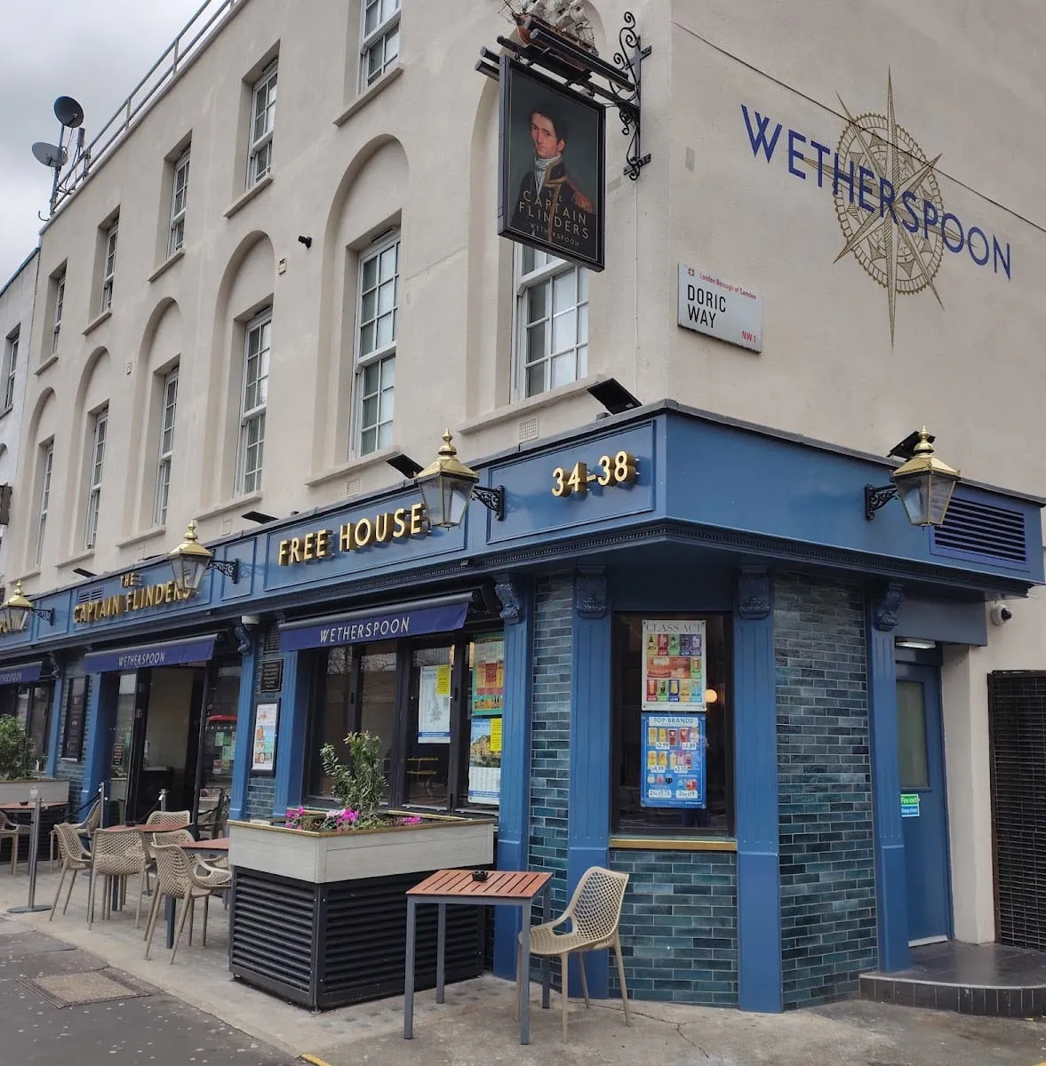 The corner exterior of The Captain Flinders near Euston, with a hanging pub sign portrait of Captain Matthew Flinders in naval dress