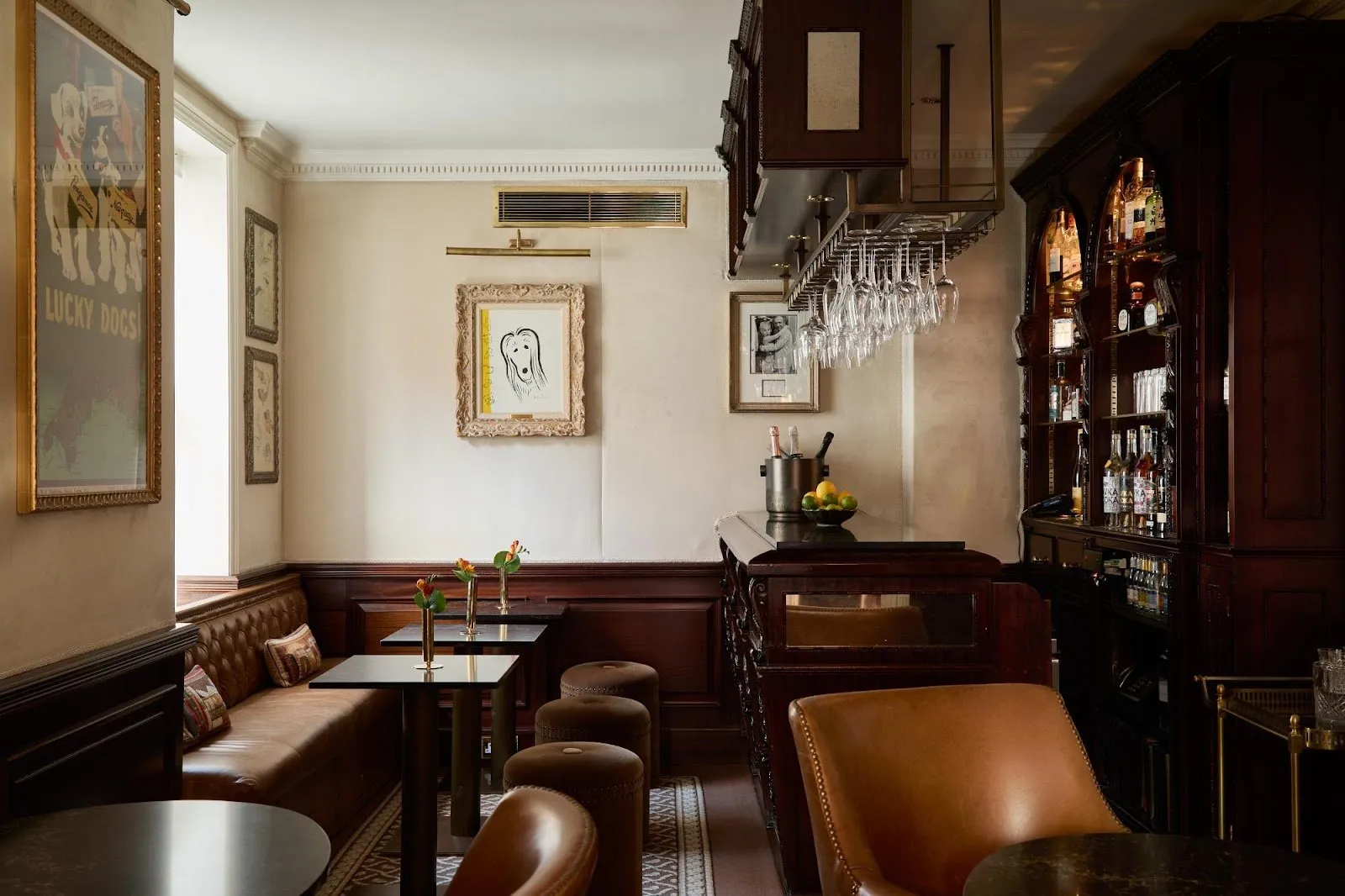 The bar at The Egerton House Hotel, with a 'Lucky Dogs!' poster, a framed sketch of a dog, and leather banquette seating