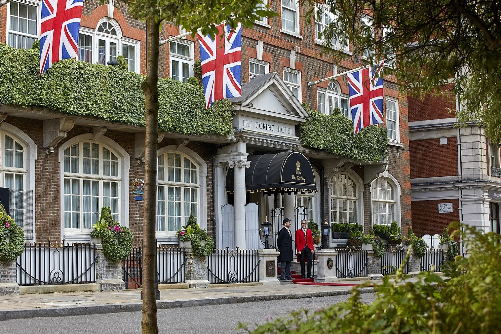 The entrance to The Goring on Beeston Place with Union flags, topiaries and a uniformed doorman