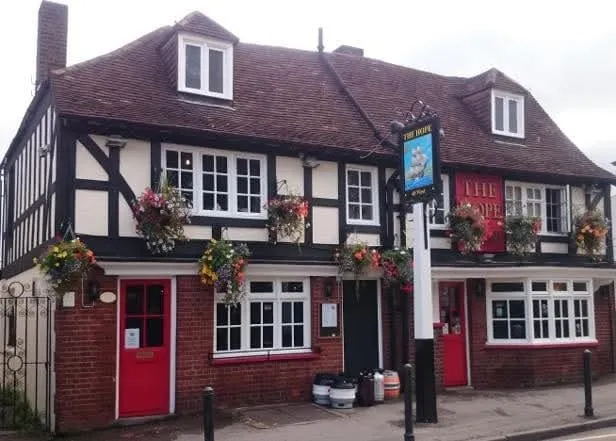 The Hope's mock-Tudor frontage on West Street, Carshalton, with red doors and hanging flower baskets
