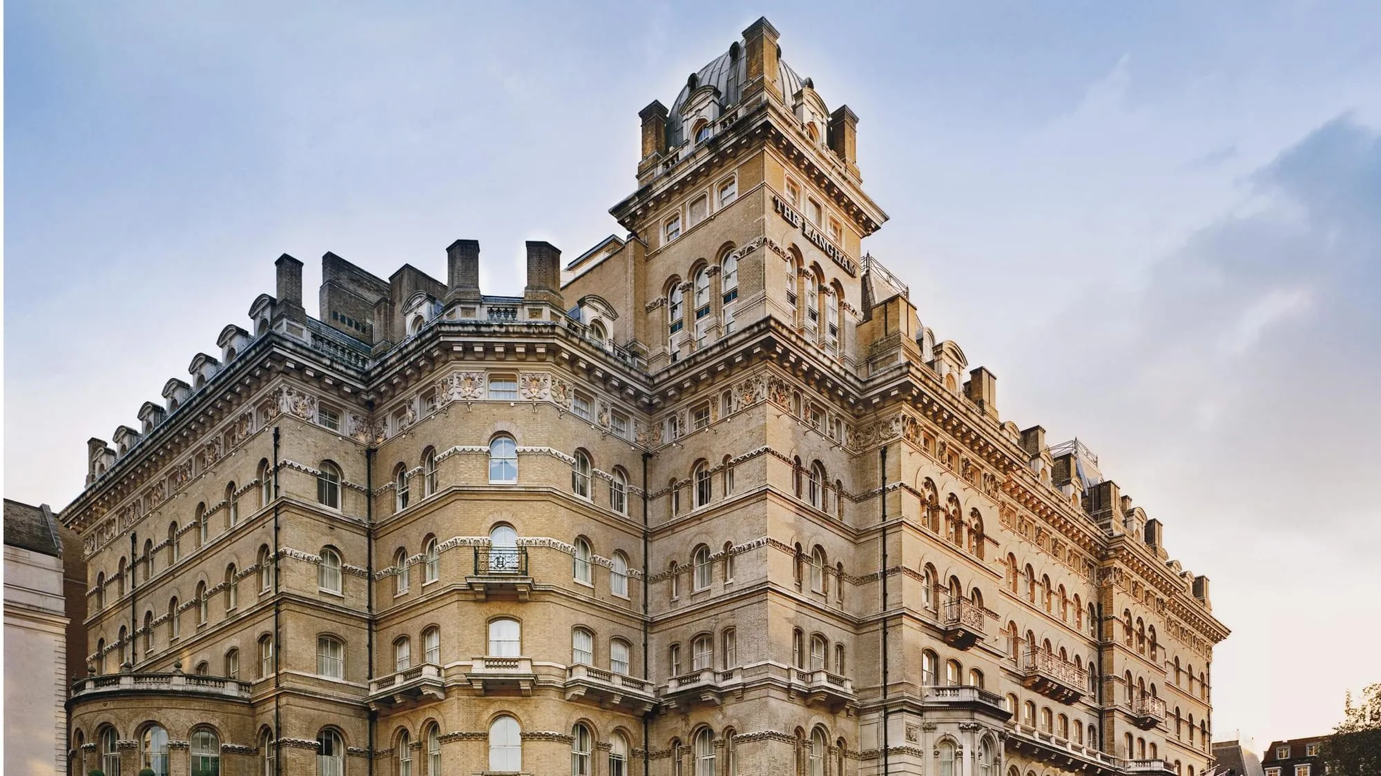 The Langham hotel's brick and stone exterior, with the hotel's name lettered above the ground-floor entrance.