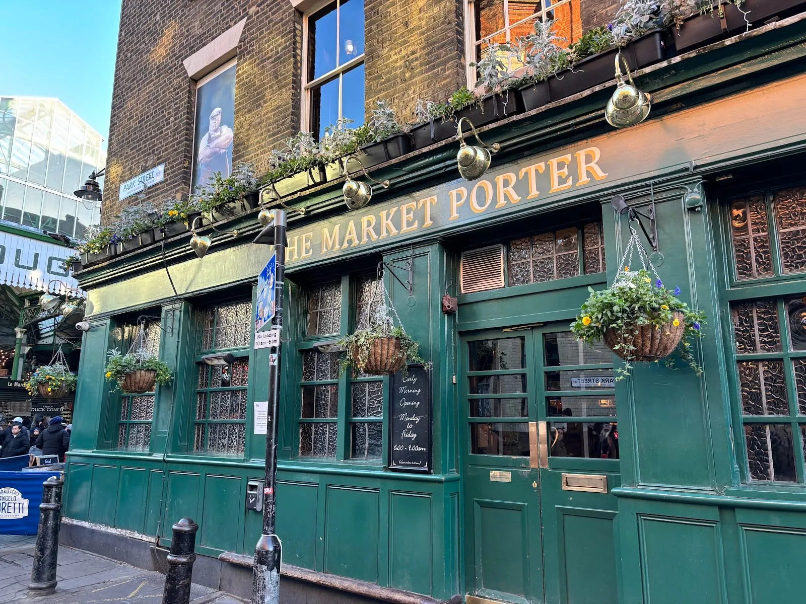 The Market Porter's green Victorian frontage at Borough Market, with a chalkboard advertising its 6am to 9am early morning opening