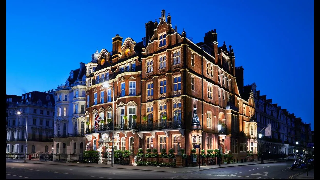 The Milestone Hotel's ornate red-brick and terracotta facade on Kensington Court, lit up at night