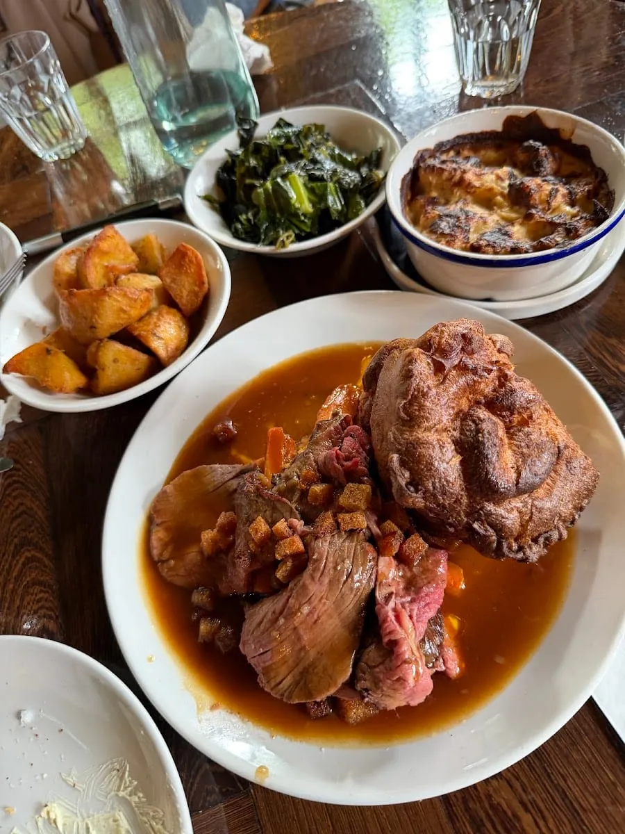 A roast dinner at The Parakeet: sliced beef with gravy, a large Yorkshire pudding, roast potatoes, greens and cauliflower cheese