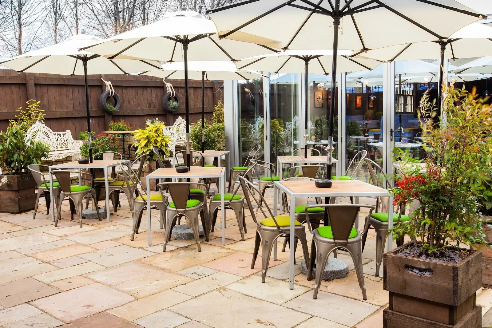 The beer garden at The Pilot, with metal chairs, square tables and white parasols