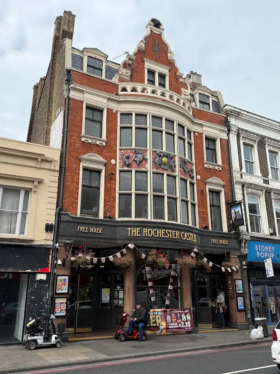 The ornate red-brick and terracotta frontage of The Rochester Castle on Stoke Newington High Street, with its Dutch-style gable and bunting strung across the entrance