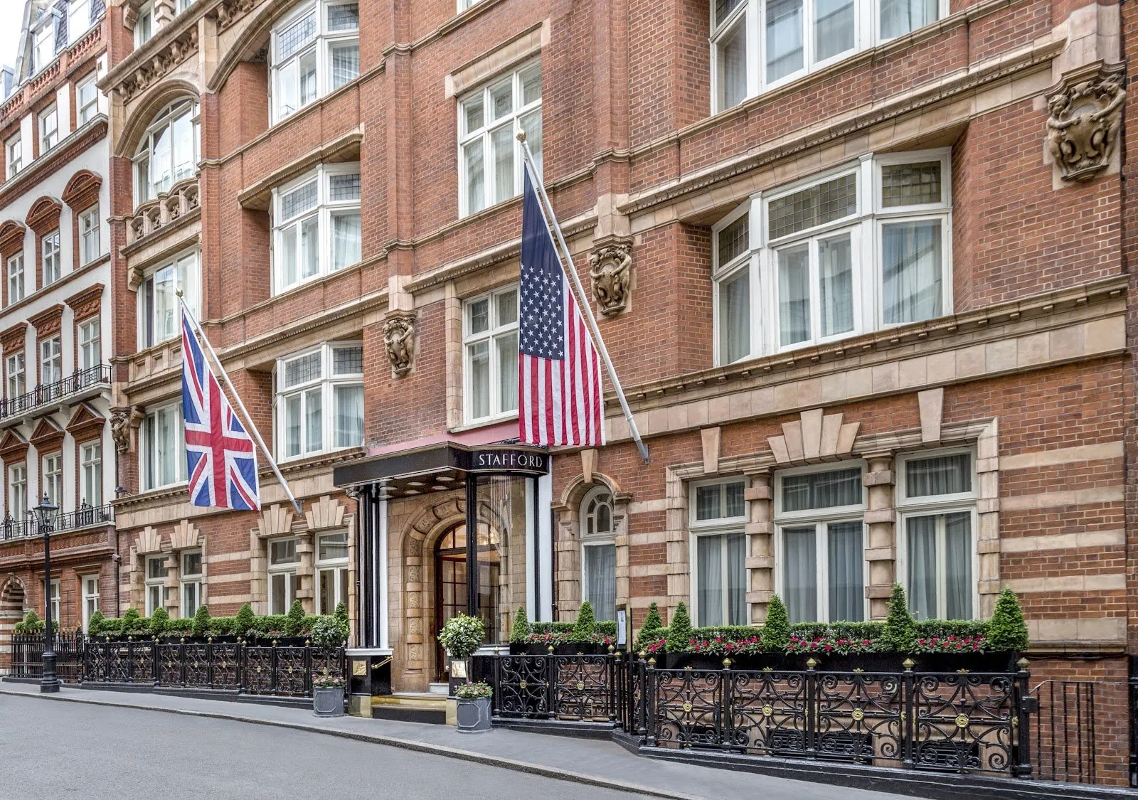 The Stafford London's red-brick facade on St James's Place, with the Union Flag and Stars and Stripes flying over the columned entrance