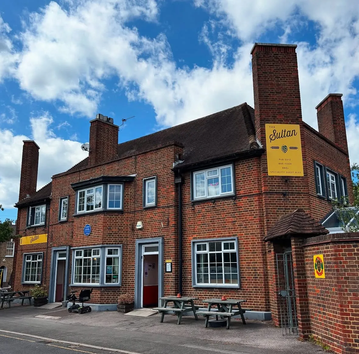 The Sultan's 1950s brick frontage on Norman Road, South Wimbledon, under a clear blue sky