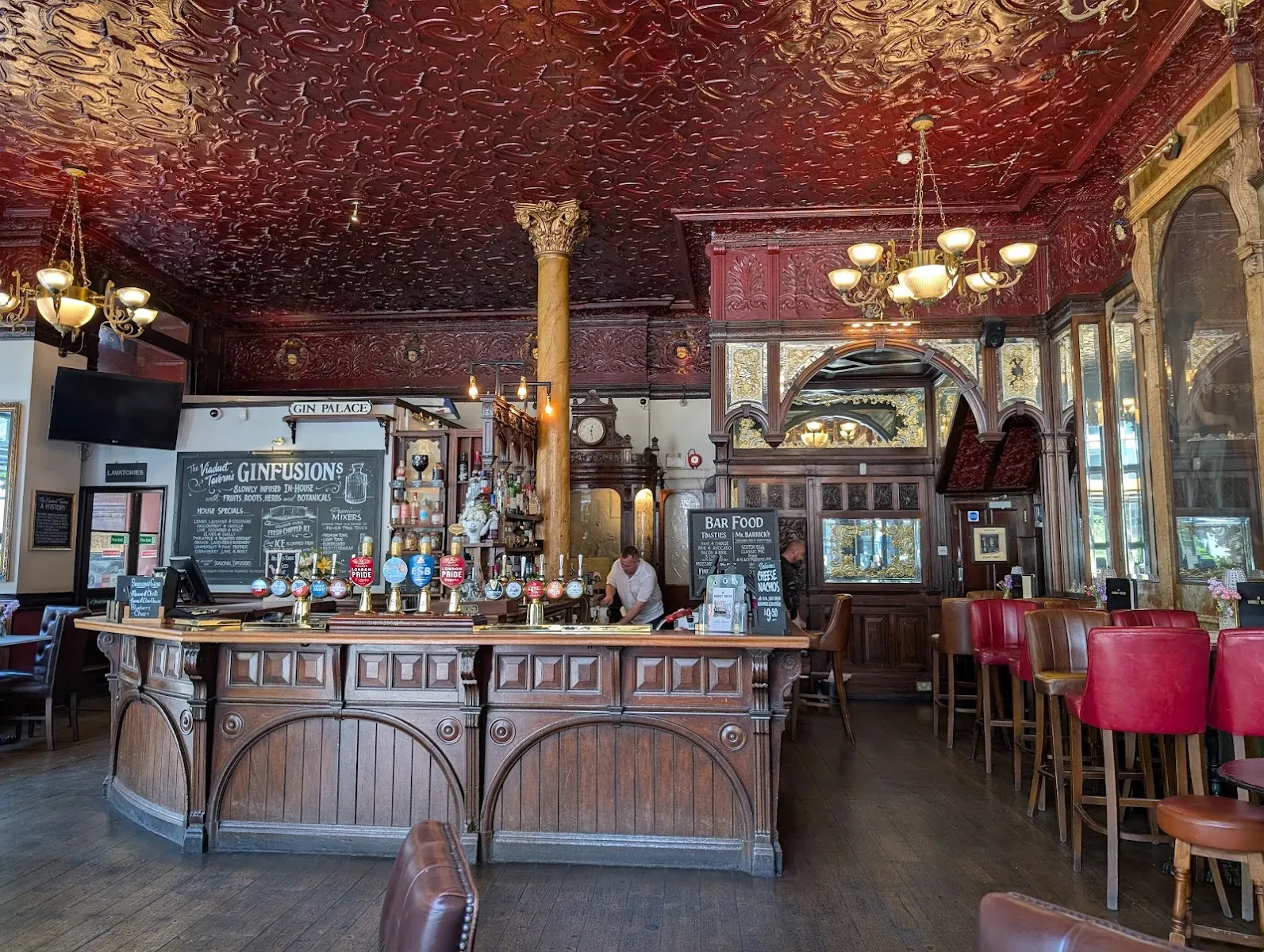The ornate red moulded ceiling and gilt mirrors inside the Viaduct Tavern's Victorian gin palace interior