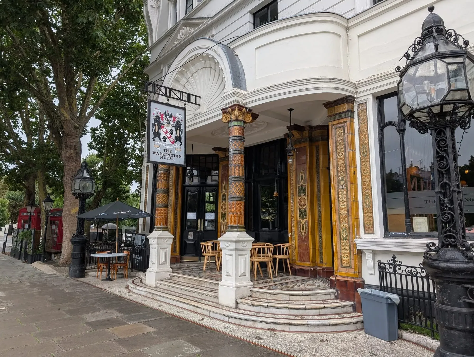 The Warrington's entrance, framed by amber art nouveau tiled columns, with the pub's coat-of-arms sign hanging above