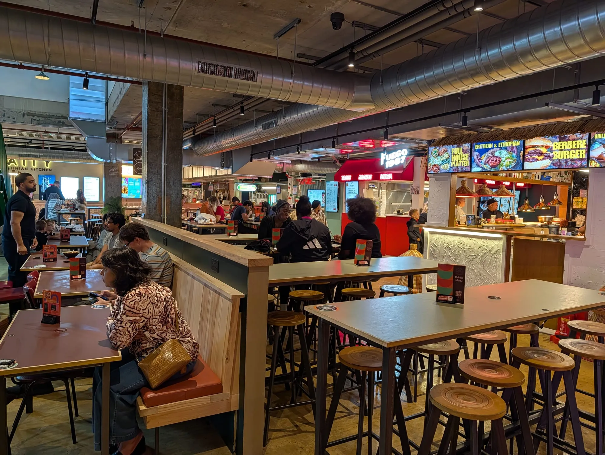 Counters and communal tables inside the Tower Bridge Collective food hall on Horselydown Lane