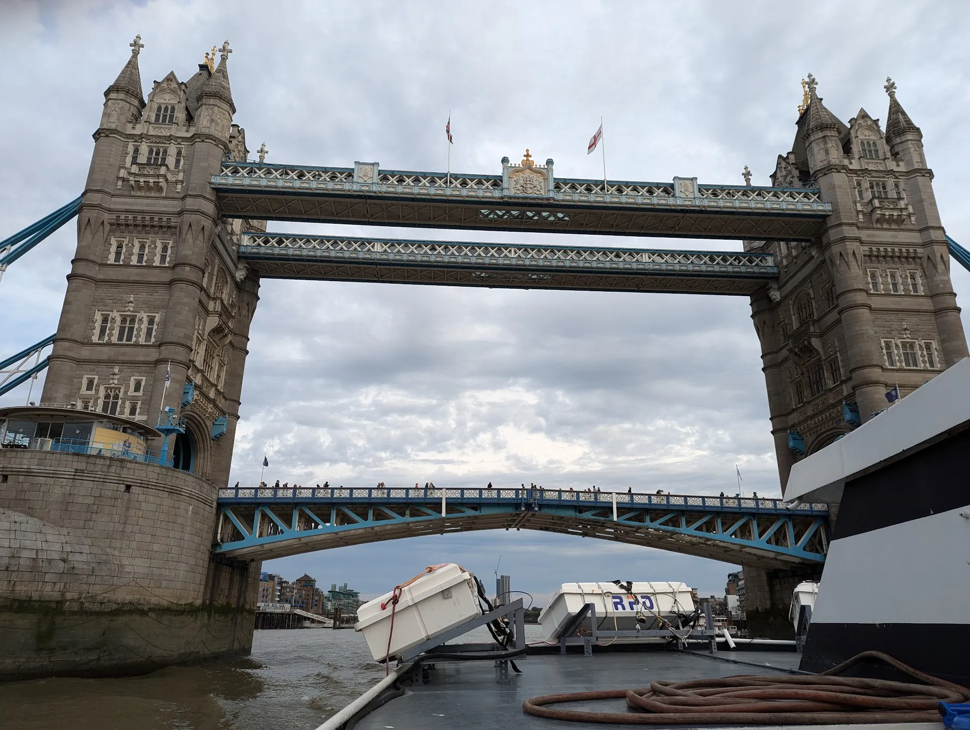 Tower Bridge seen from the deck of a river boat passing directly beneath it.