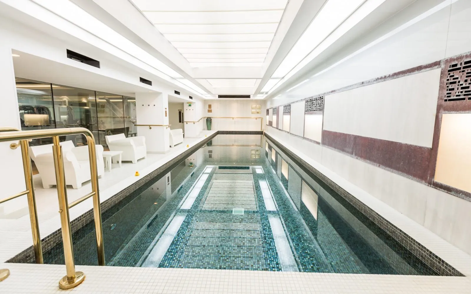 The 15-metre indoor swimming pool at Town Hall Hotel in Bethnal Green with brass railings, mosaic tiles and overhead skylights