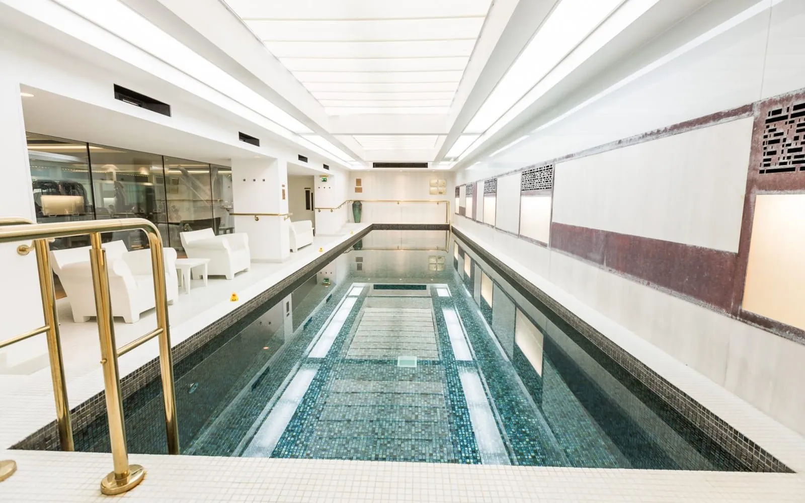 The indoor pool at Town Hall Hotel, under a long skylight, with brass handrails at the near end