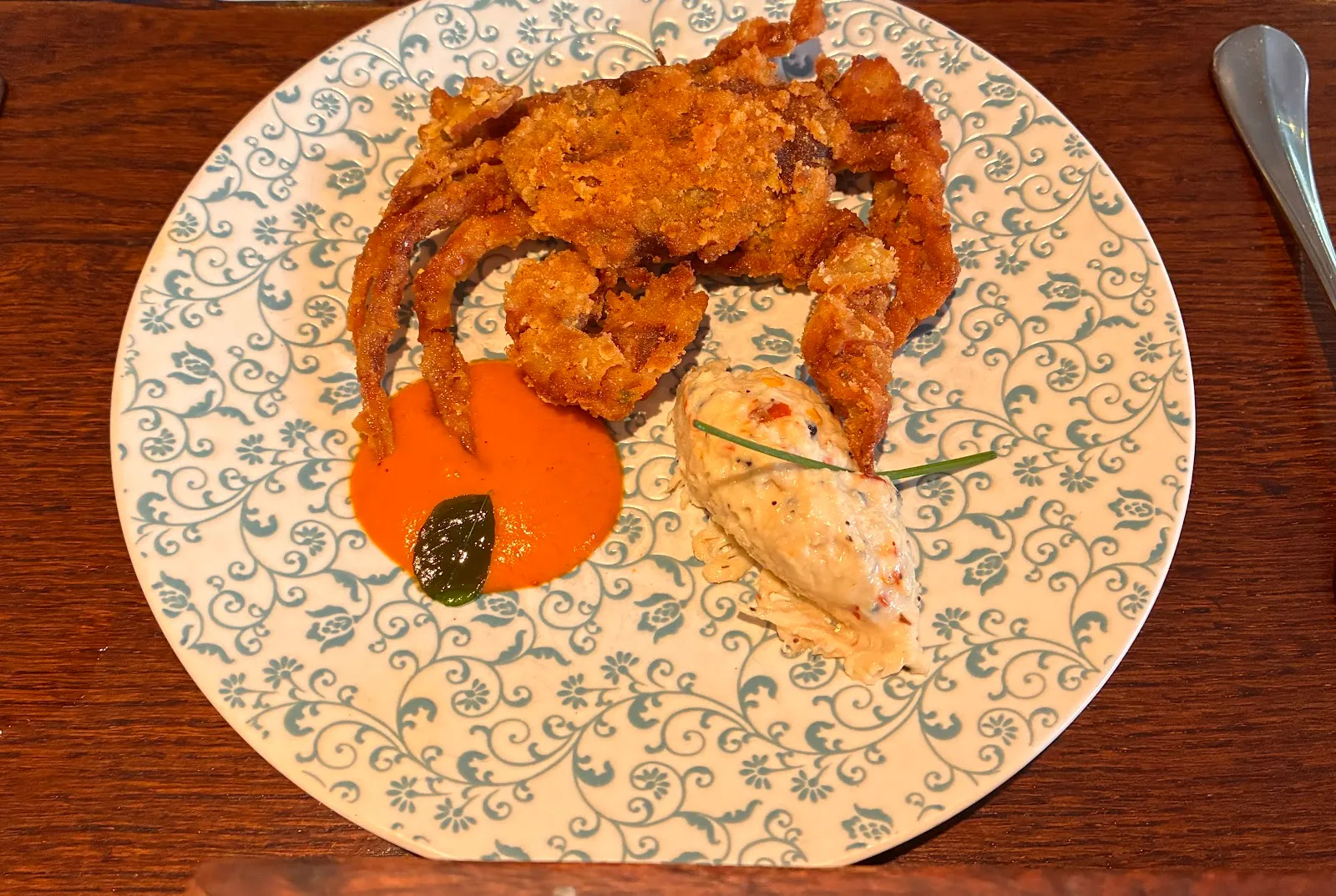 Butter pepper garlic soft-shell crab served with coconut crab salad and chilli chutney on blue patterned china at Trishna