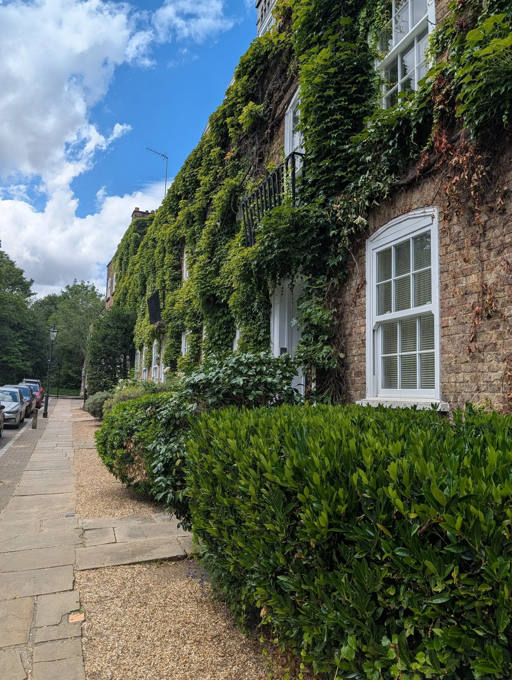 An ivy-covered brick cottage in the Vale of Health, a small hamlet inside Hampstead Heath