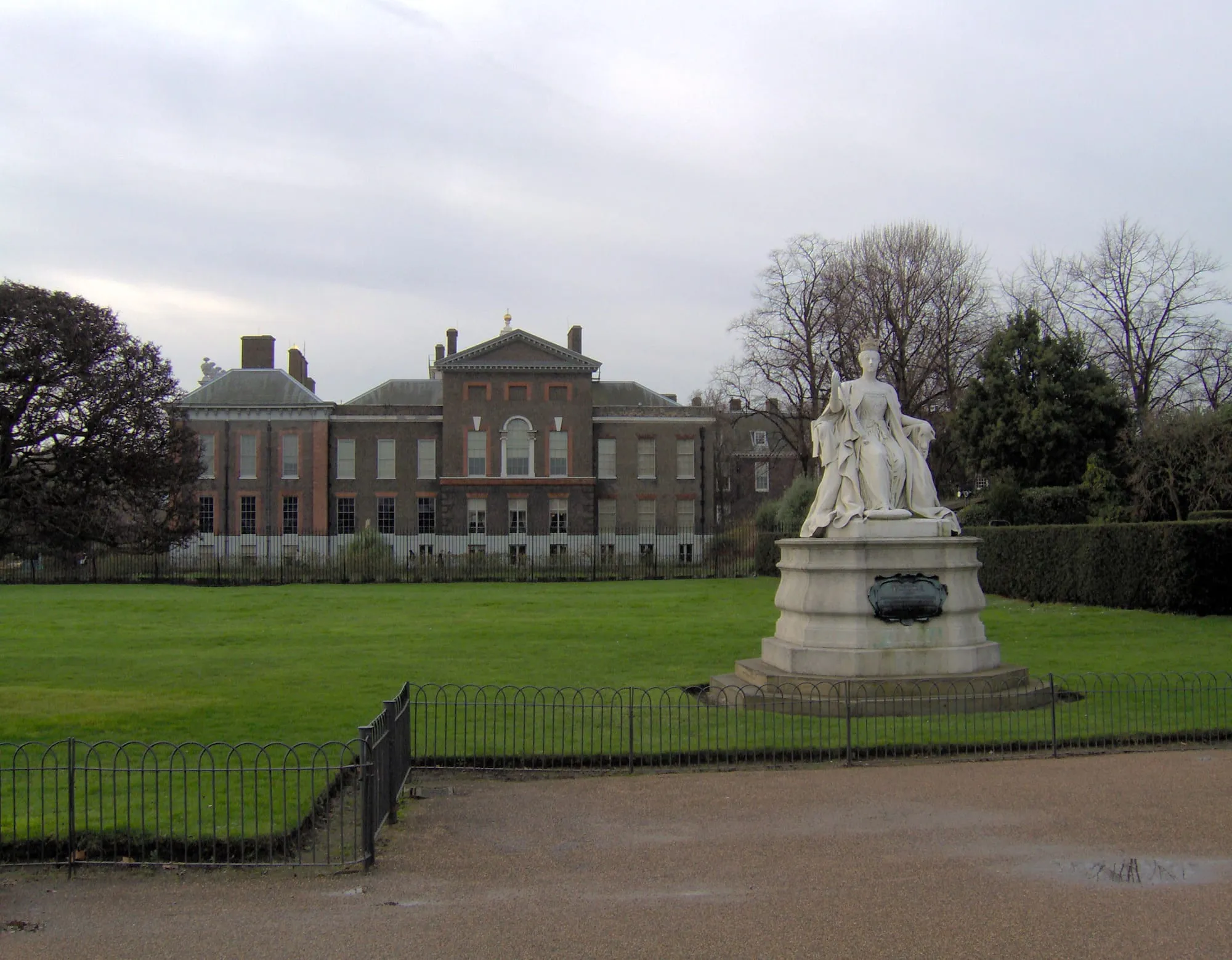 The statue of Queen Victoria outside the red-brick frontage of Kensington Palace