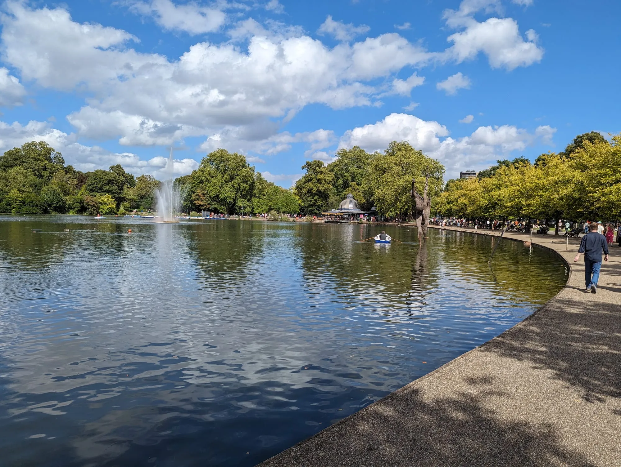 The boating lake in Victoria Park with a fountain playing and trees along the far bank