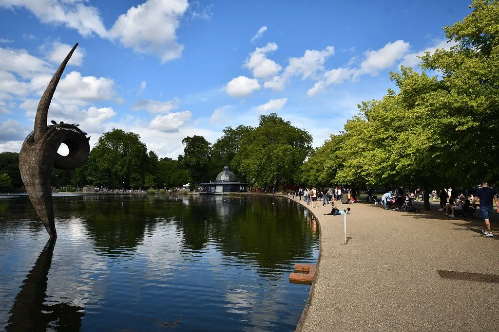 The boating lake in Victoria Park with a pagoda on the far bank and people along the path