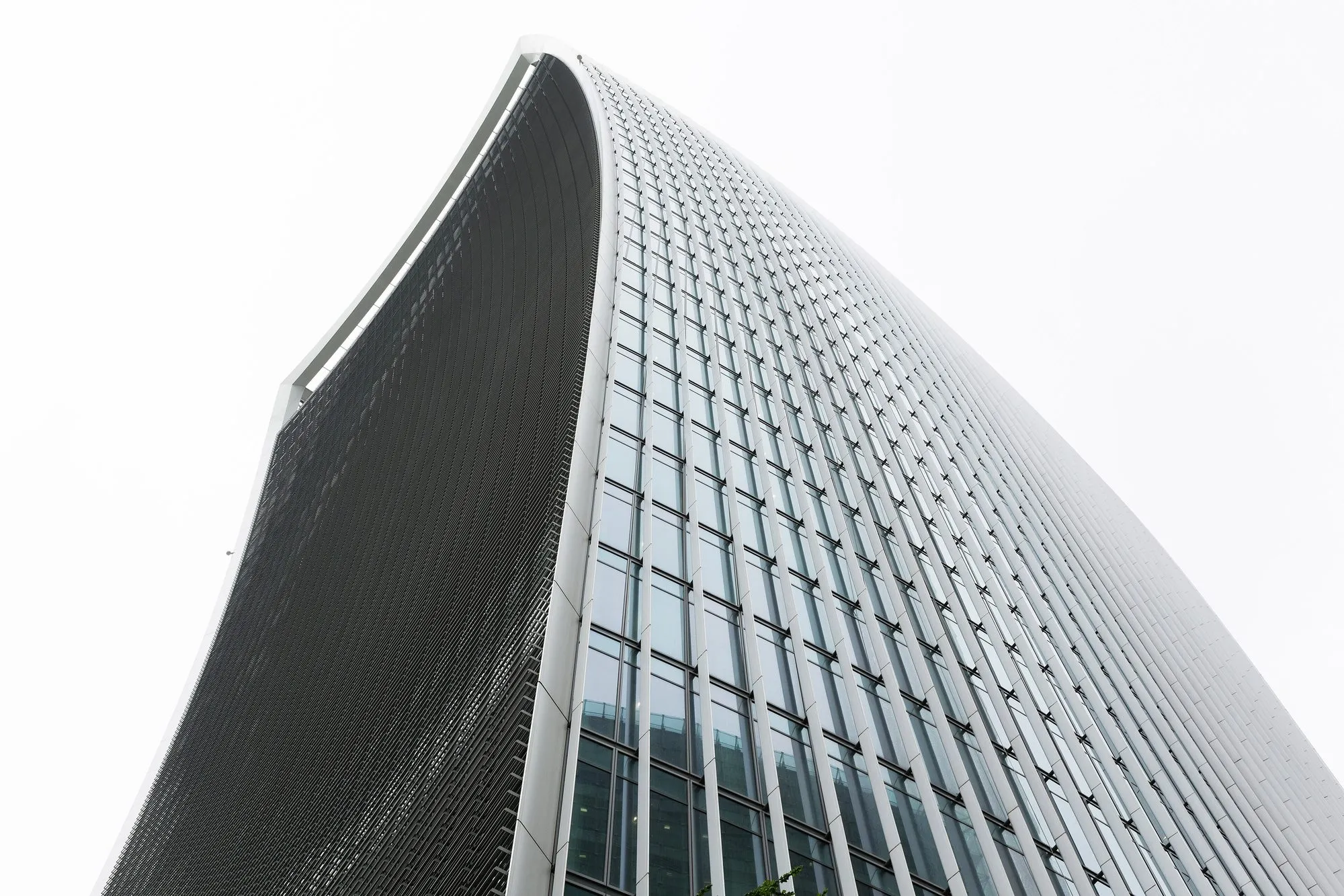 The concave glass face of 20 Fenchurch Street seen from the street directly below, flaring outwards towards the top