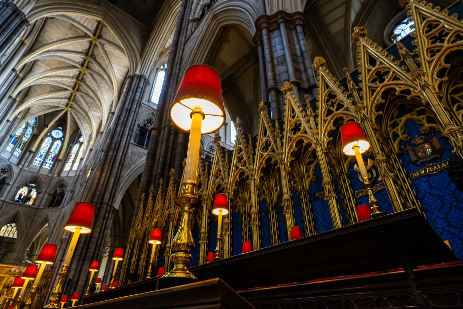The Victorian Gothic Quire stalls with illuminated brass lamps beneath soaring ribbed vaulting inside Westminster Abbey