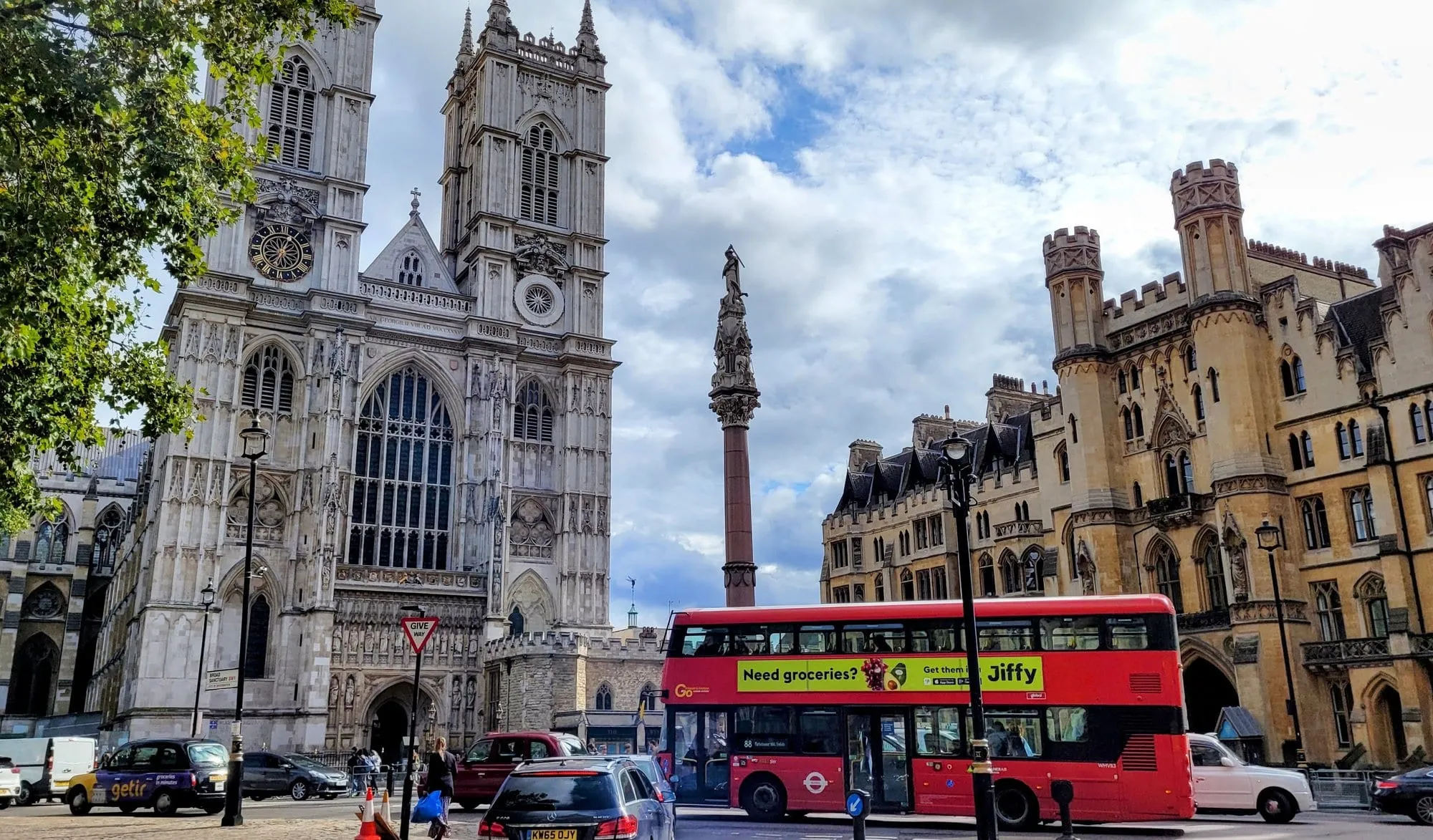 Westminster Abbey's twin west towers rising above a red London bus in the foreground