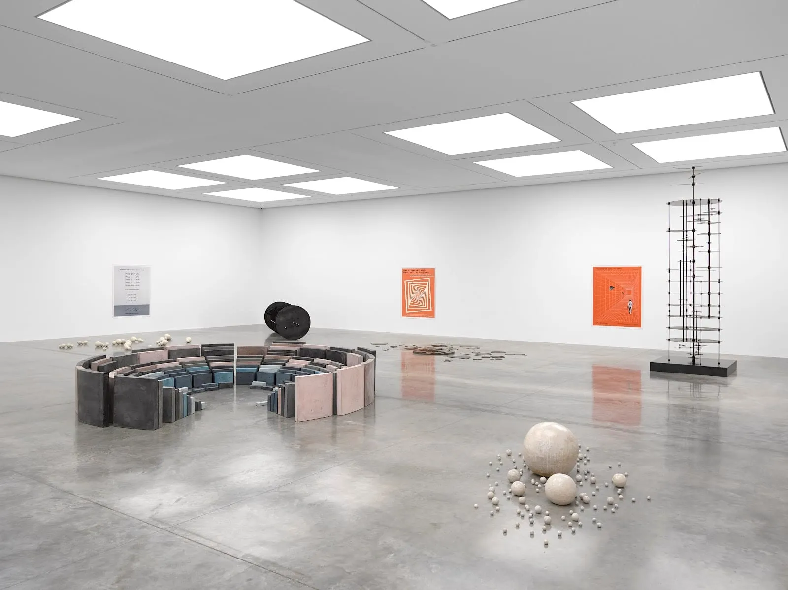 A vast white gallery room at White Cube Bermondsey with sculptures and prints spaced far apart and no visitors in sight