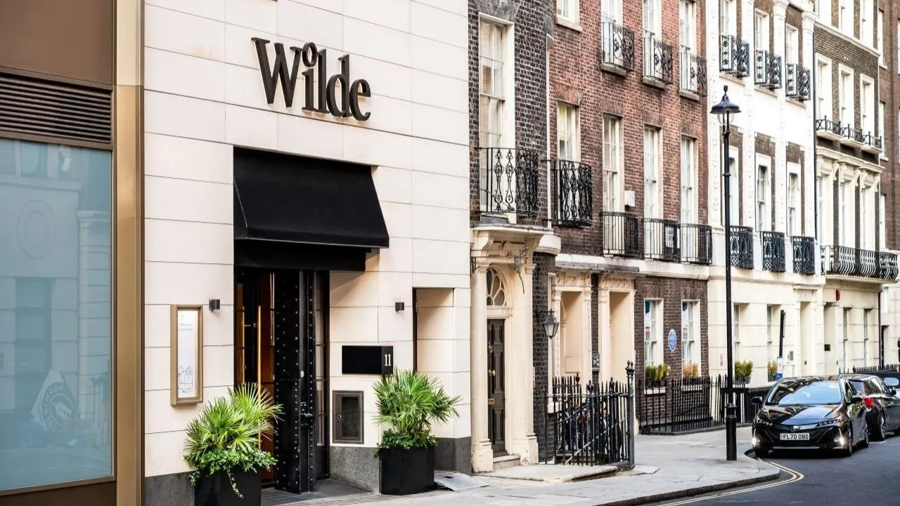The Wilde townhouse entrance on a Covent Garden side street, with the Wilde sign over a black awning between period brick buildings