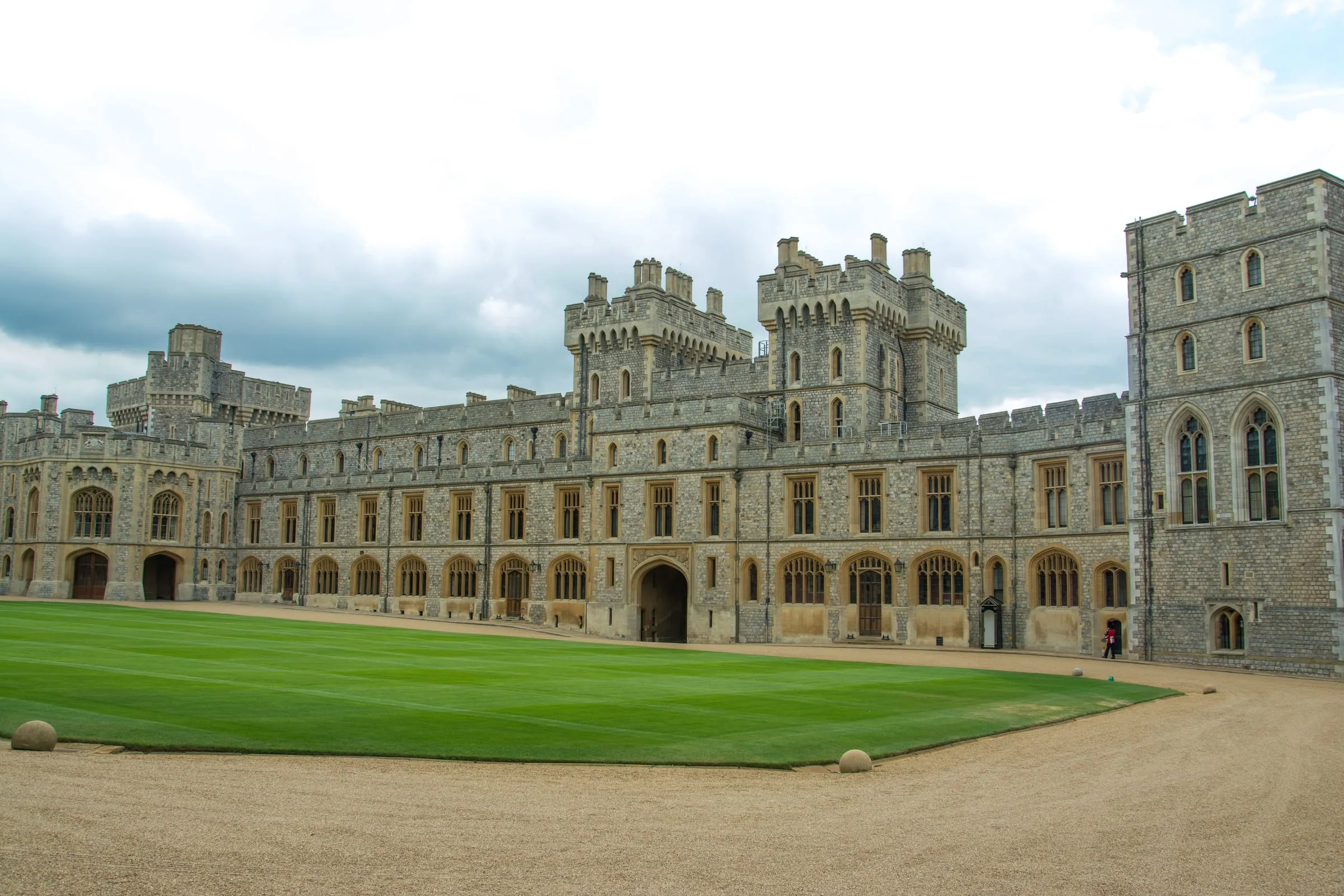 Windsor Castle's Upper Ward, the State Apartments and round towers behind a wide lawn under a blue sky