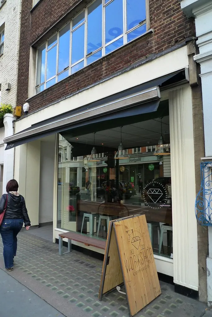 The open frontage of Workshop Coffee with a passer-by