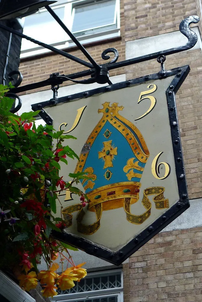 The painted hanging sign of Ye Olde Mitre showing a bishop's mitre and the date 1546