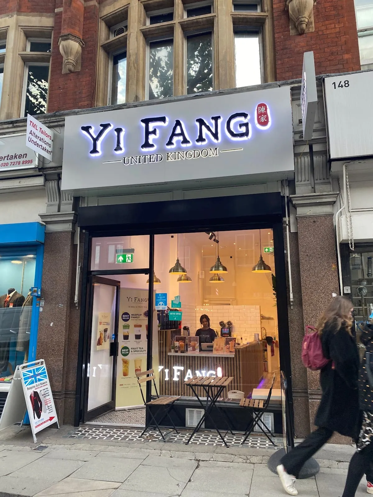 Yi Fang's white-and-grey shopfront on Gray's Inn Road, with a few tables and pendant lights visible through the window