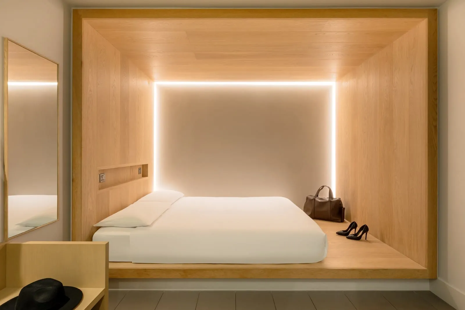 A Cocoon room at Zedwell Piccadilly Circus, with the bed built into a full wood-lined nook and a full-length mirror to one side